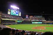 Baseball field at night, scoreboard displays a player, Twins 