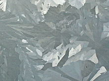 Merged elongated crystals of various shades of gray.