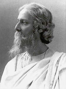 Late-middle-aged bearded man in white robes looks to the left with serene composure.