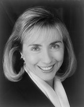 Black-and-white close-up photographic portrait of the same woman as in the top photo, in her forties and with shoulder-length blonde hair