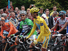 A man in yellow clothes. In the background people are watching.