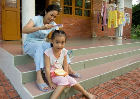 An SOS Mother helping get her child ready for school