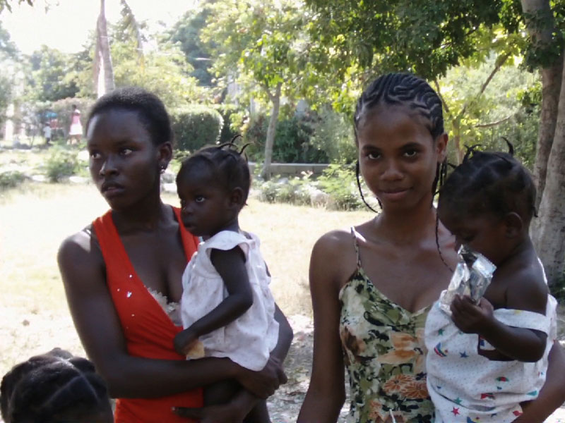 Twins orphaned by the earthquake cuddled by older girls in SOS Village