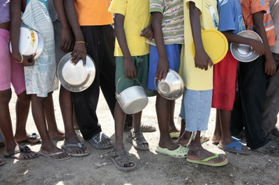 Children holding plates, waiting for meals at SOS food distribution point